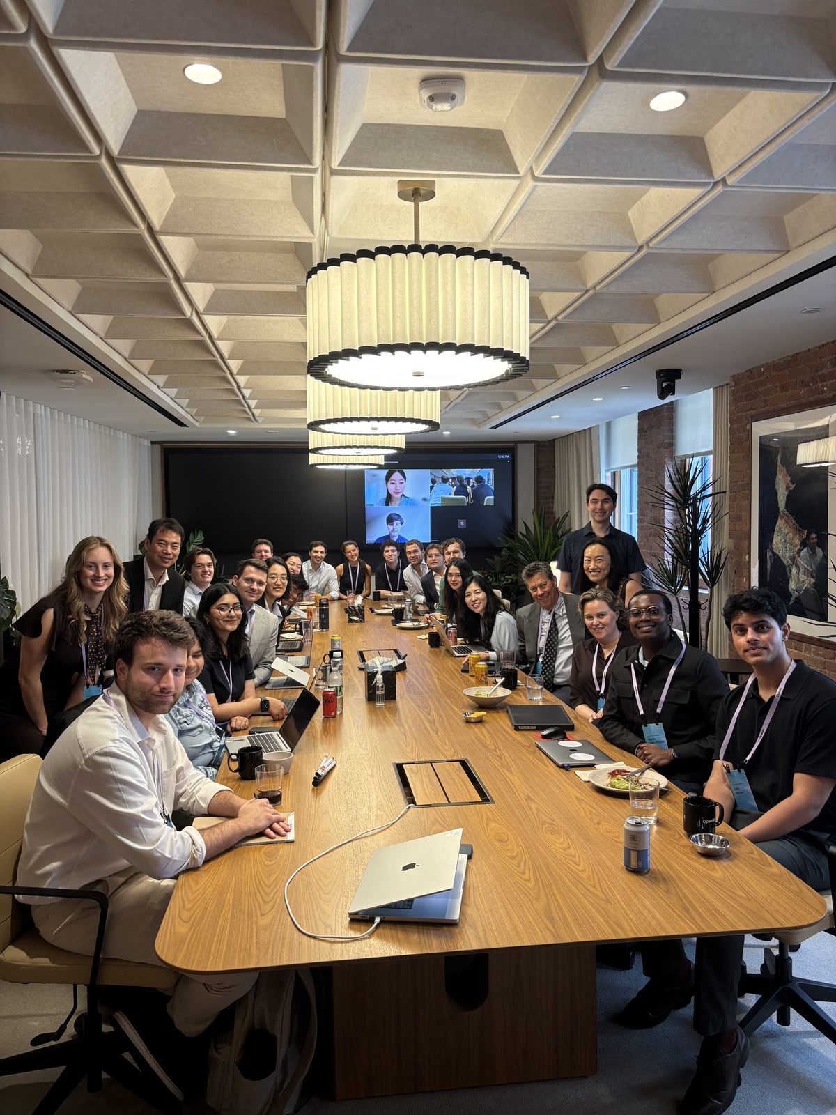 The seminar seated around a long conference table at OpenAI's New York headquarters, with further participants joining on the wall screen by Zoom.