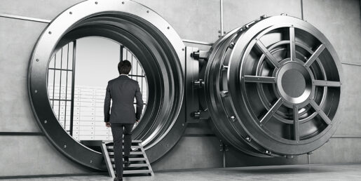 A man in a suit stares into a bank vault.