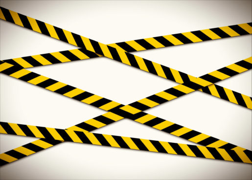 Black and yellow caution tape criss crosses against a white background.