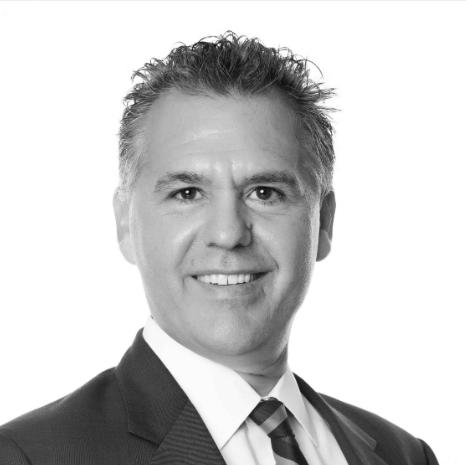 Black and white headshot of man with suit and short hair.