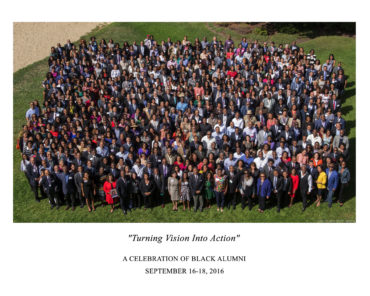 Group shot of several hundred people standing in a field from above.