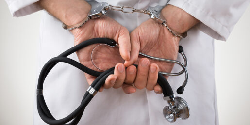 This image shows a set of handcuffed hands holding a stethoscope.