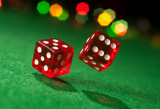 An image of two red dice with white dots.