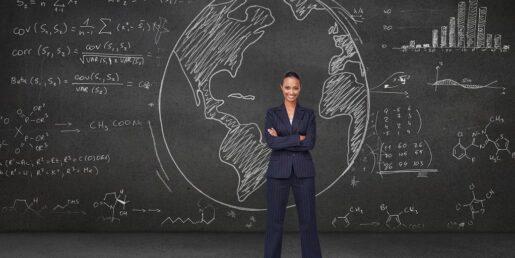 An image of a women standing in front of a chalk board depiction of planet Earth.