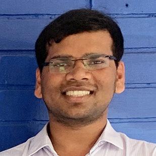 South Asian male smiling at camera.