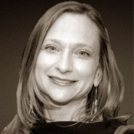 Woman with medium length light brown hair smiling.