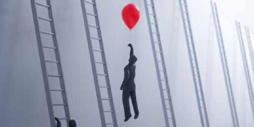 An individual ascending with a red balloon.