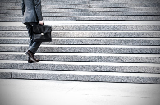 A man in a suit climbs government concrete stairs.