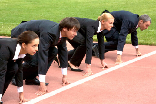 Individuals dressed in suits beginning a track race.