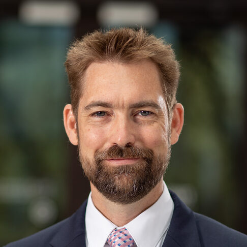 Man with short brown and and beard smiling.