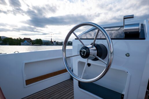 A modern steering wheel at the front of the boat.