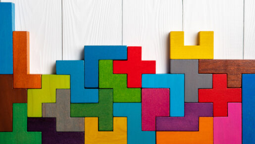 Top view on colorful wooden blocks folding on white wooden background.