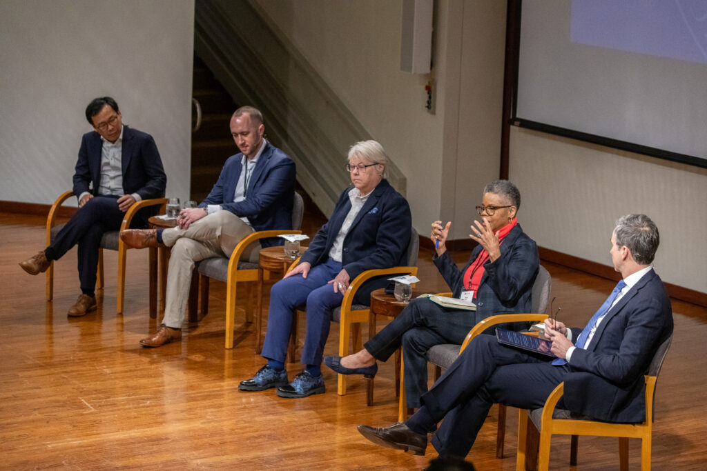 Five individuals sit on a stage.