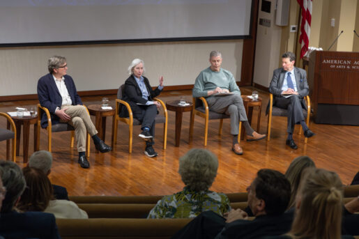 Four panelists sit on stage.