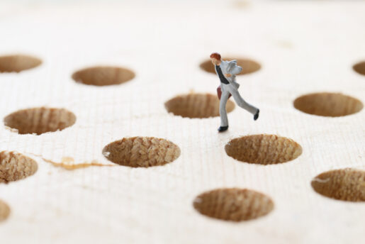 A man jumps around trying to avoid holes.