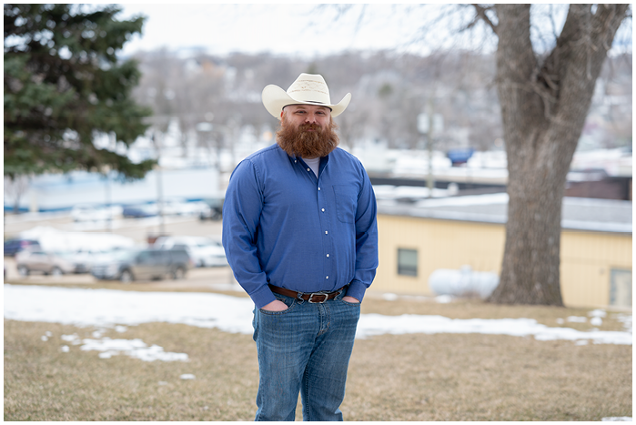 Photo of Dylan Kirchmeier wearing a cowboy hat and standing in front of melting snow.