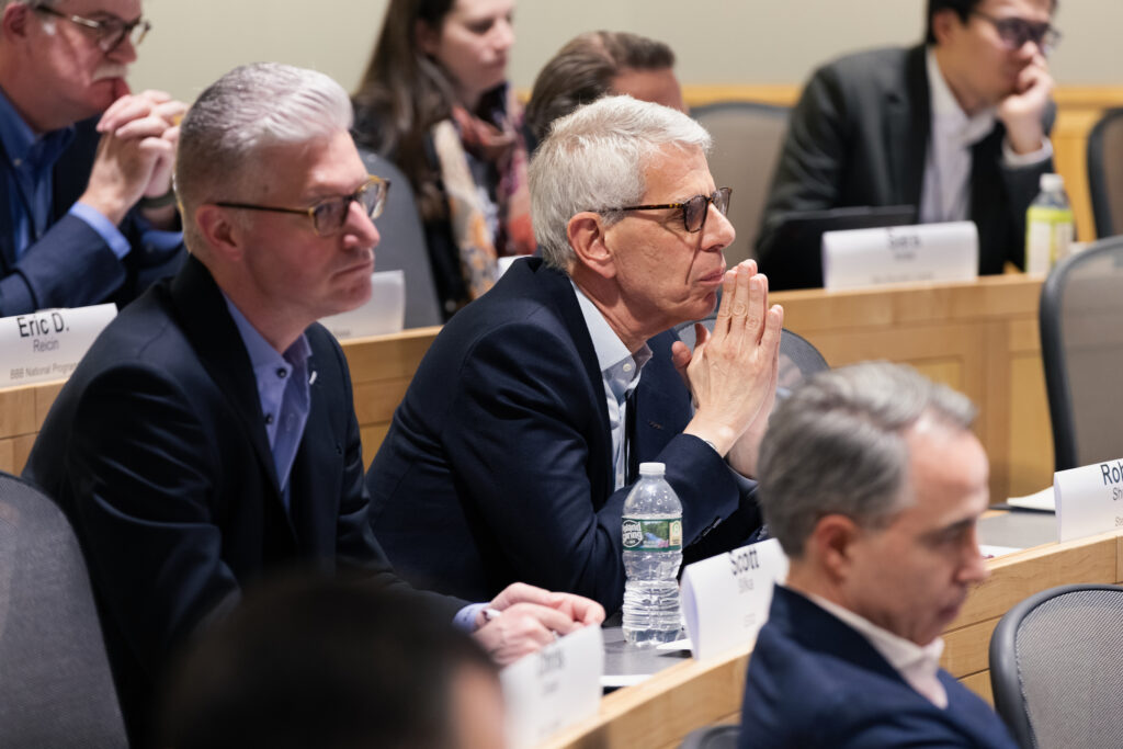 Participants listen intently in a classroom.