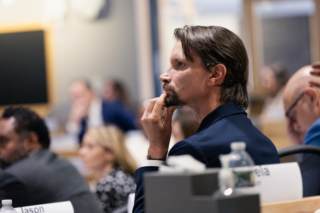 A man looks on and listens in a classroom.